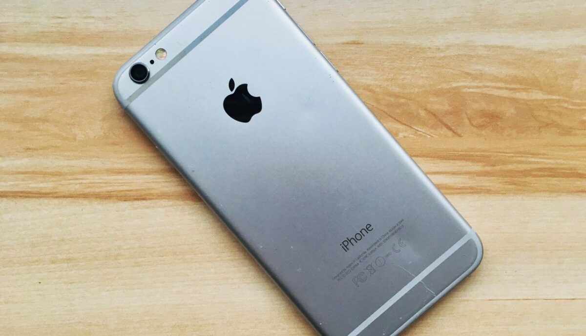 A silver iPhone six laying face-down on the floor.